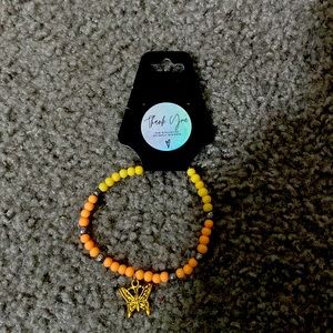 Handmade multi color bracelet with a butterfly charm
